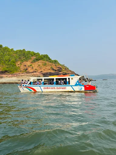 The boat on calm green water beside a small wooded island