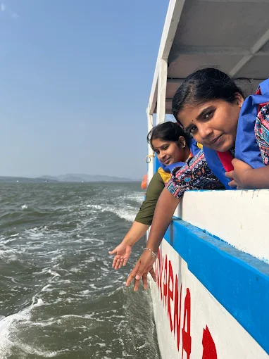 Guests leaning over the side of the boat to touch the sea